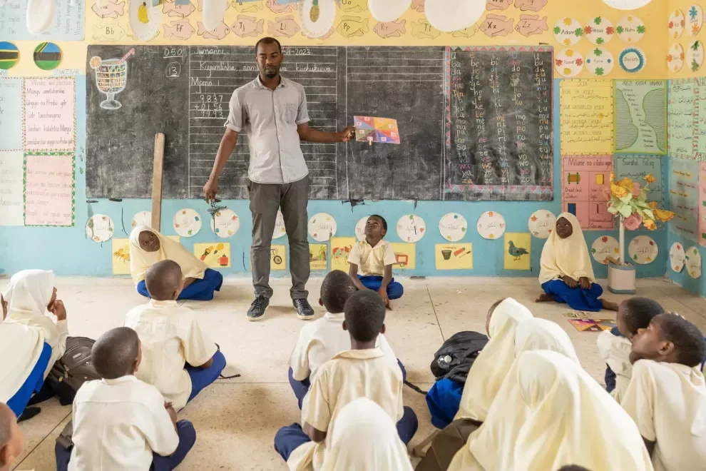 A teacher leading a class of students in a colorful classroom